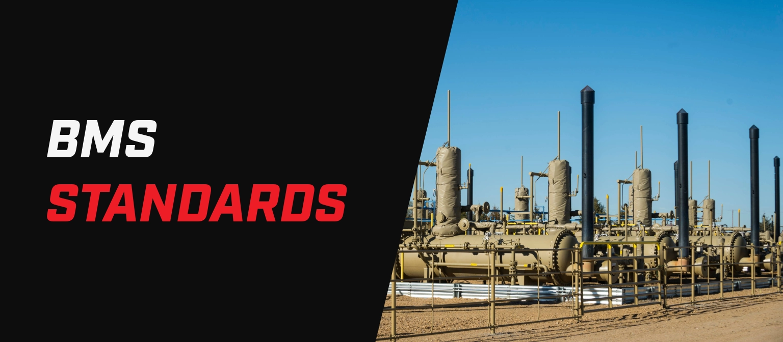 Banner with the text “BMS Standards” beside an outdoor oil and gas facility with multiple vessels, piping, and vertical exhaust stacks.