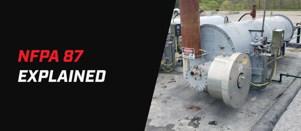 Banner graphic for an article titled “NFPA 87 Explained.” The left side features the text “NFPA 87” in red and “EXPLAINED” in white on a black background. The right side shows an industrial thermal fluid heater system with large cylindrical vessels, piping, control panels, and a burner assembly at an outdoor facility. A visible warning sign reads “DANGER HOT DO NOT TOUCH.”