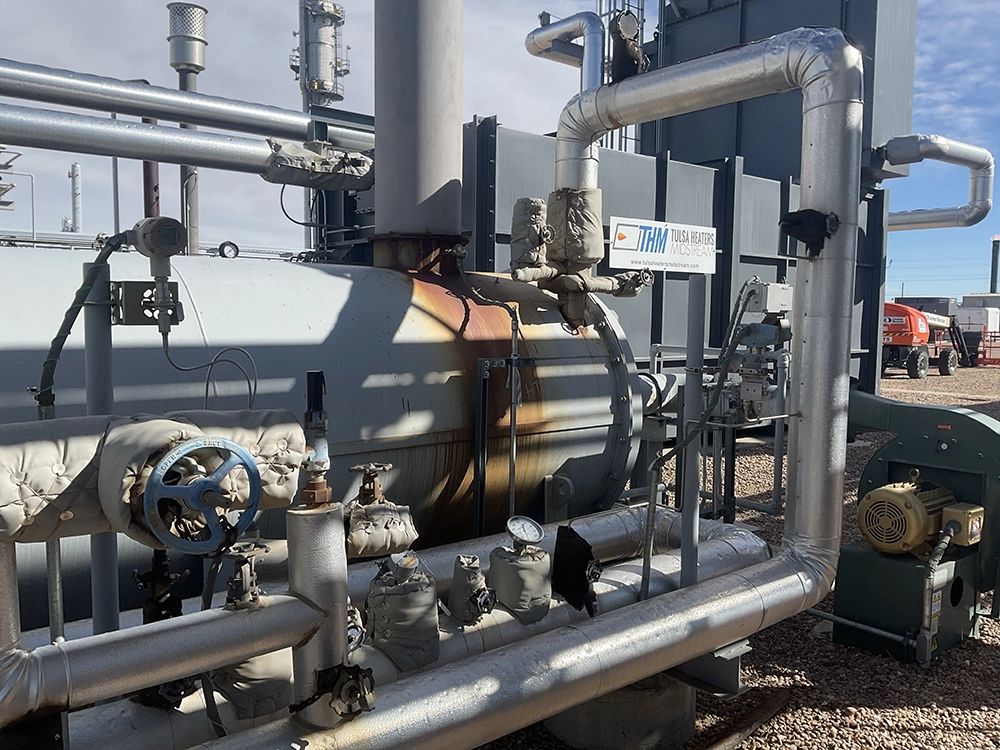 Rear section of an industrial heater showing insulated piping, burner air blower, and connected instrumentation.