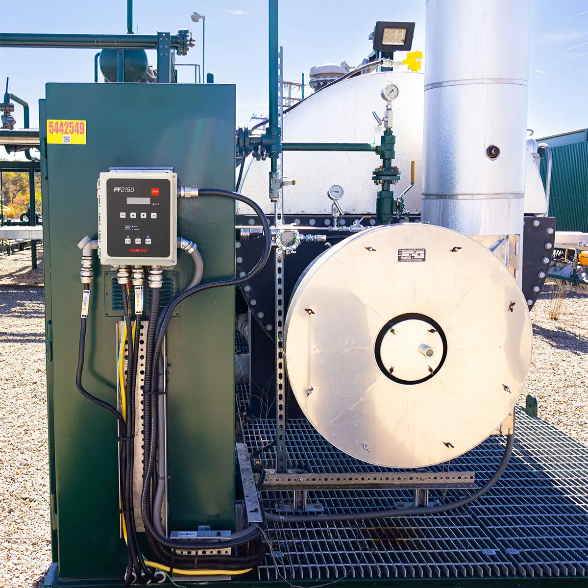 Profire PF2150 controller mounted on a green panel beside a heater vessel at a production site